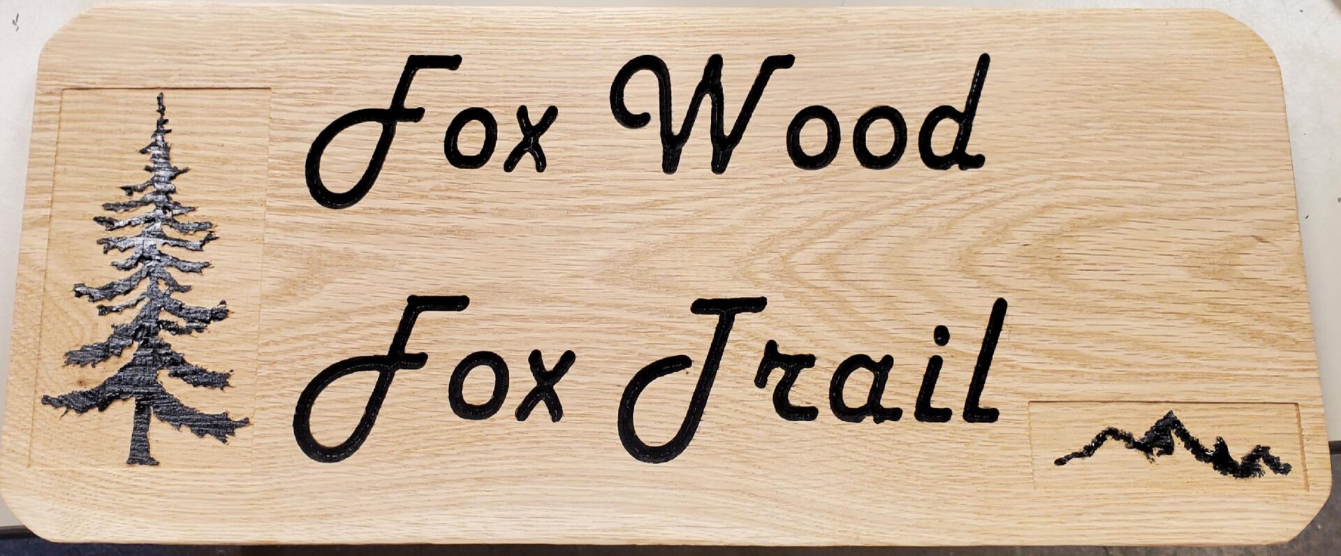 Wooden carving of fox wood fox jrail with a tree in it.